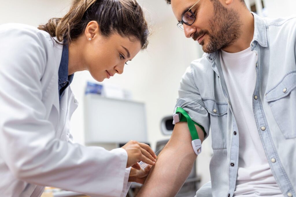 A phlebotomist preparing for a blood draw in a patient’s arm.