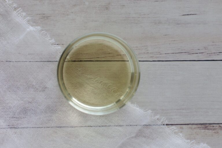 A small glass cup of Abyssinian oil sitting on a table waiting for someone to experience Abyssinian oil for hair benefits.