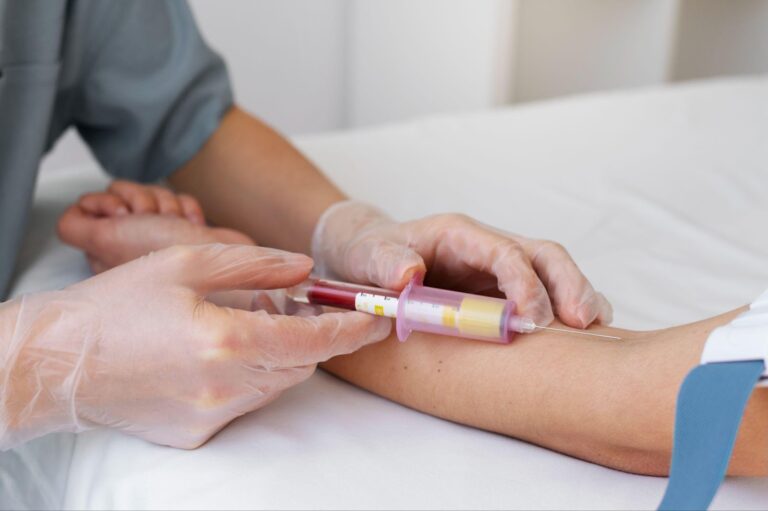 A phlebotomist drawing blood from a patient’s arm.